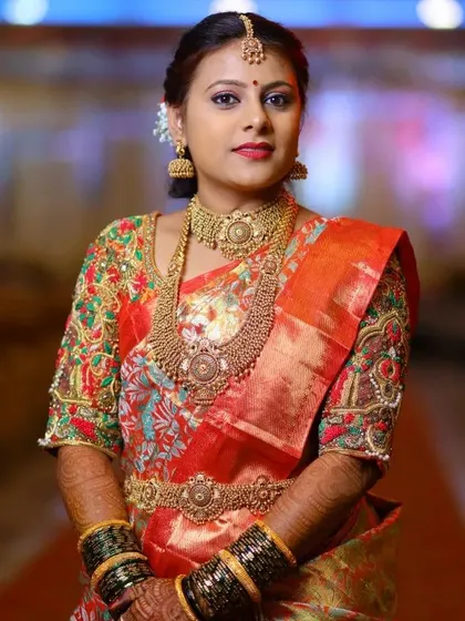 A full view of this happy client's wedding look. The heavily embroidered blouse is the centerpiece, designed to complement her traditional gold jewelry and saree.