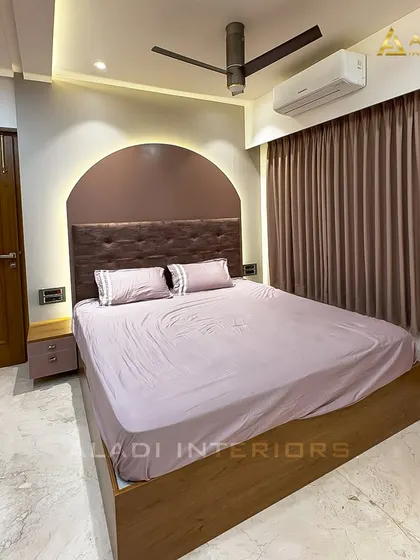 Another perspective of the bedroom, highlighting the warm ambient lighting from the false ceiling and the headboard, which creates a relaxing mood.