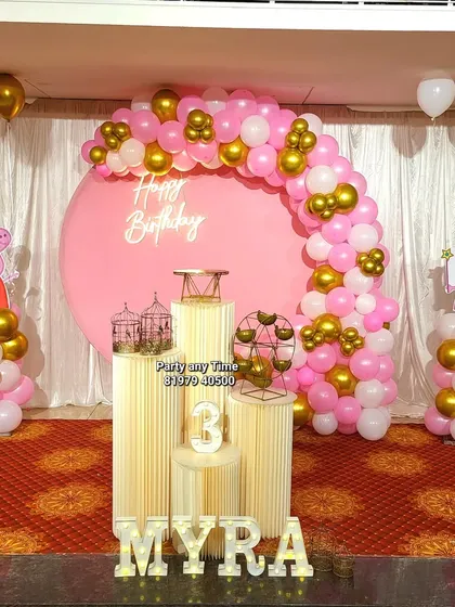 A cute Peppa Pig theme for a 3rd birthday, with a pink circular backdrop, a pink and gold balloon arch, and character cutouts.