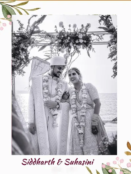 A classic black and white portrait of the couple, framed by their wedding arch against the backdrop of the Goan sea.