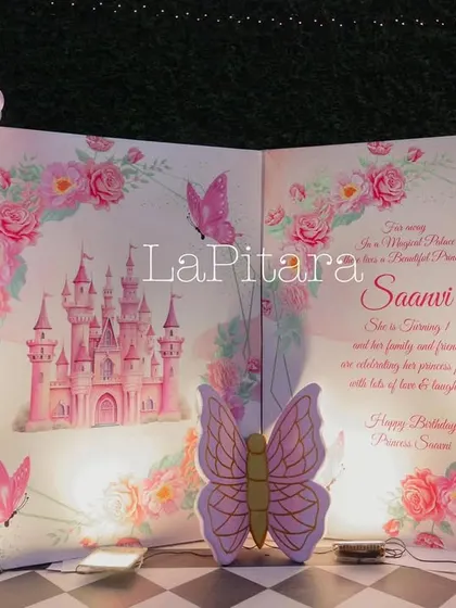 A storybook-style photo booth, where the party invitation is written on the pages of a giant open book, framed by a beautiful balloon arch.