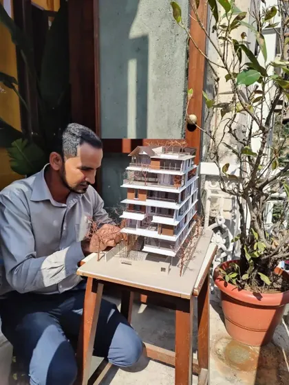 Our model maker, Vijay, puts the finishing touches on a detailed architectural model of 'The Light House'. The model sits in the sun, allowing us to study how light will interact with the final building.