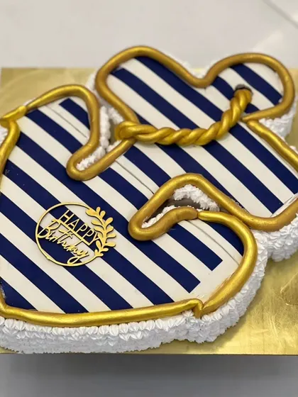 An anchor-themed cake with a nautical blue and white stripe pattern. The golden rope detail adds a touch of class. This is a great custom design for someone who loves the sea.