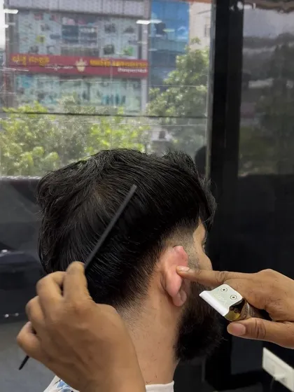 Using a detailer to create a sharp line. This is a crucial step for a clean and polished haircut.