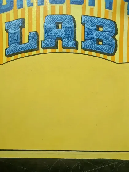 Another in-progress image of the "Curiosity Lab" sign, showing the patterned letters and the blank space ready for the next stage of painting.