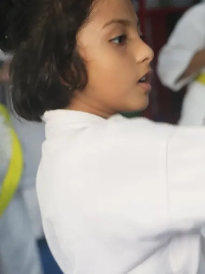 A young student demonstrates her technique during the belt exam. Each student is assessed on their form, power, and understanding of the karate principles we teach.
