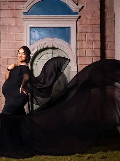 A dramatic shot of a flowing black gown against an architectural backdrop at night. This creates a powerful and elegant silhouette.