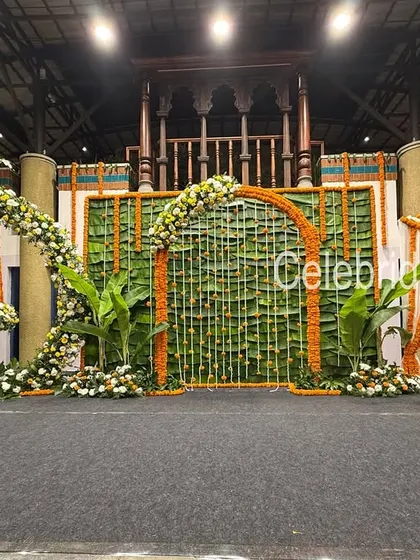 A unique naming ceremony setup featuring a floral swing, a banana leaf backdrop, and a marigold-decorated photo corner.