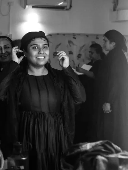 An actor smiles in the mirror during a costume fitting for "The House of Bernarda Alba."