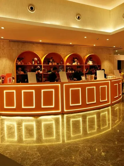 The stylish, illuminated bar set up for the Sangeet night. A well-designed bar is a key social hub, and we ensure it aligns perfectly with the event's theme, both in its structure and its curated drink offerings.