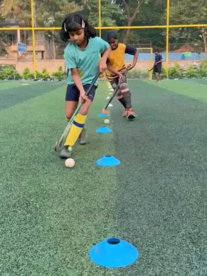 A young player practices dribbling drills through cones during a conditioning session. These exercises are designed to improve agility, coordination, and fitness.