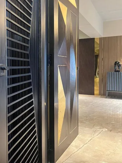 The entrance to the Juhu residence makes a statement with a custom-designed door featuring geometric brass inlays. It sets the tone for the luxurious and artfully designed interiors that lie within.