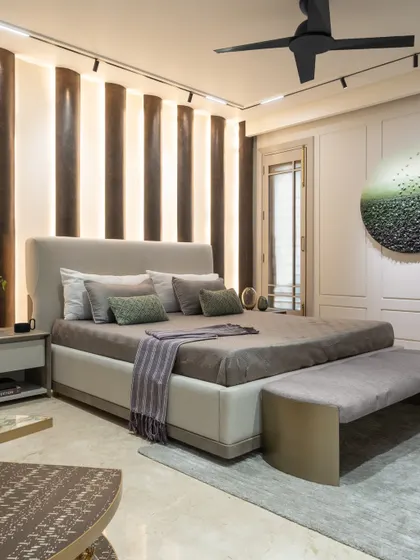 In this modern loft master bedroom, we used a monotonous theme to create a serene atmosphere. The curved, textured headboard adds character, while the circular art piece with an ombre finish complements the room's calm, beach-inspired vibe.