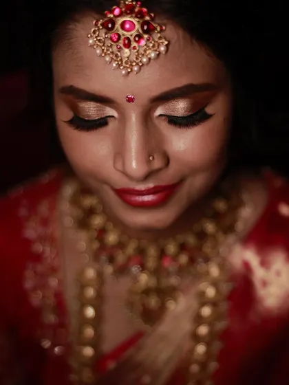 A close-up of a classic bridal look with golden eyeshadow and a red lip. This is a timeless combination that looks stunning on every bride.