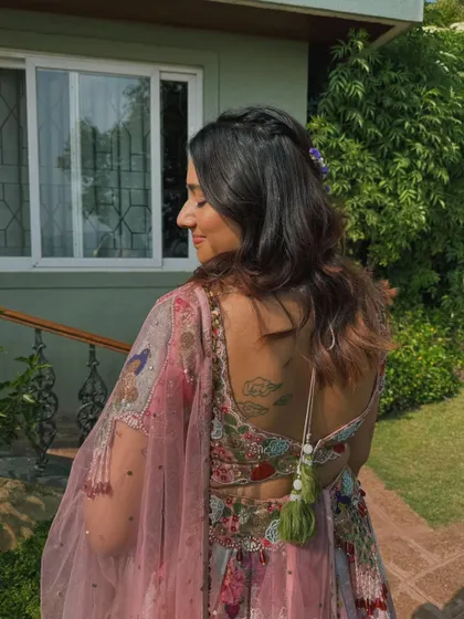 A view of the back, showing the beautiful hairstyle and the intricate details of her blouse.