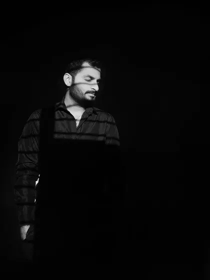 A low key, black and white portrait with strong shadows falling across my face. An example of using shadow and light to create a moody, introspective character shot.