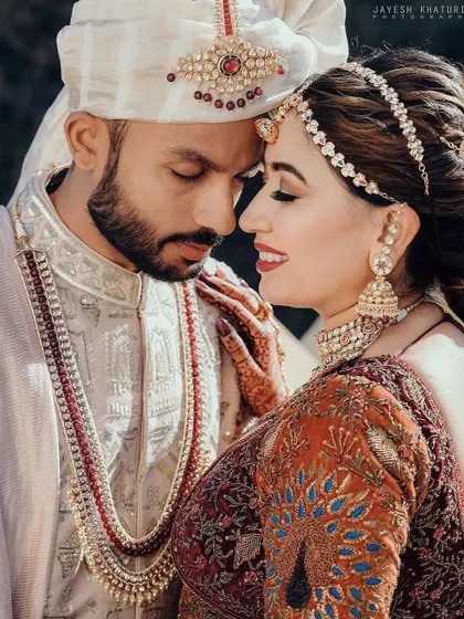 A romantic couple portrait where you can see the bride's elegant hairstyle peeking out from under her dupatta.