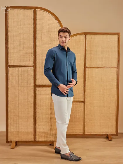 Another look at the deep teal shirt and white trousers combination, showcasing its modern fit and the effortless elegance of a high-contrast pairing.