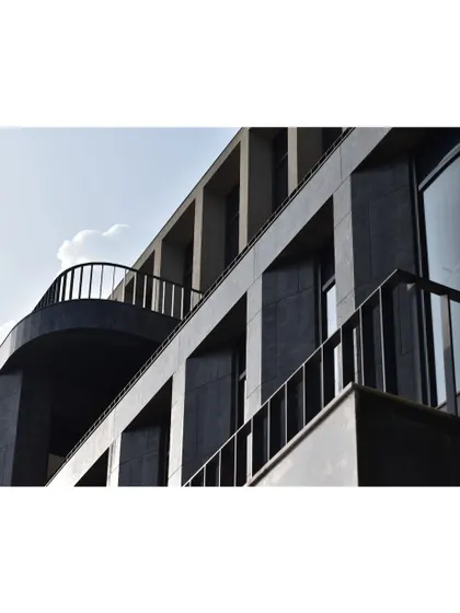 A detail of the curved balcony and railings on the '378' office building. This element softens the building's strong grid-like facade, introducing an elegant curve that adds character and a human scale.