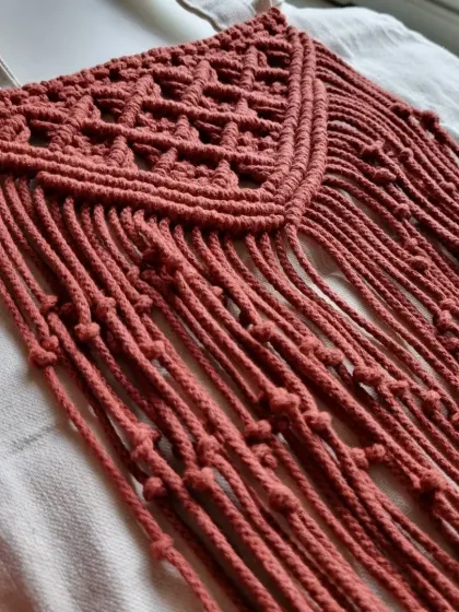 A side view of the macrame panel on my tote bag, showing the texture and fringe against the canvas.