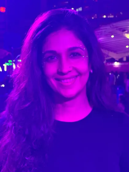 A happy client at India Cocktail Week, smiling with her subtle and pretty glitter freckles.