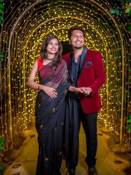 A romantic shot of the couple, where the delicate floral embroidery on the black saree stands out beautifully.