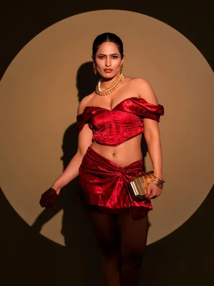 A powerful stance in a red co-ord set, framed by a perfect circle of light. This is a great example of how we use lighting equipment to create graphic, impactful compositions.