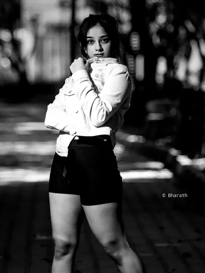 This black and white portrait uses the shadows and light of the outdoor path to create a dramatic and moody atmosphere.
