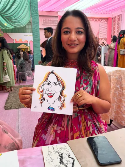 A guest poses with her portrait at a beautifully lit evening wedding reception.