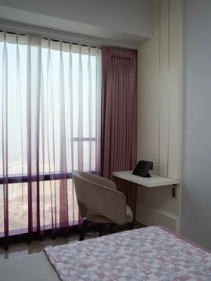 A detail of the guest room's smart features, including automated shaded purple sheer curtains that gently filter natural light, adding a dreamy quality to the space.