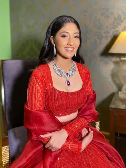 A radiant smile from this beauty in red. The makeup is all about enhancing her features and creating a flawless canvas for her glamorous look.