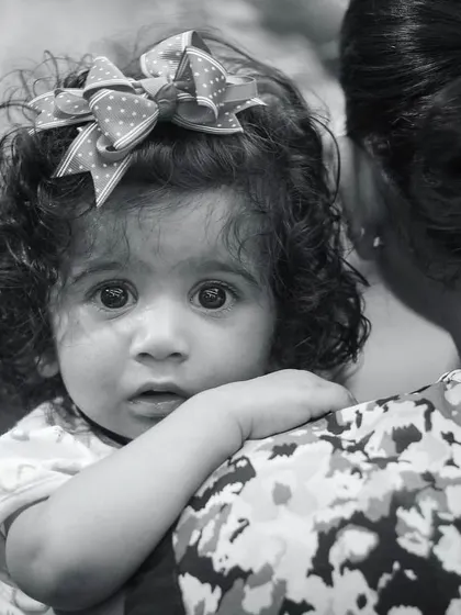 Innocence is like polished armor. This black and white portrait of a baby looking over her mother's shoulder is both defending and endearing, a truly classic shot.