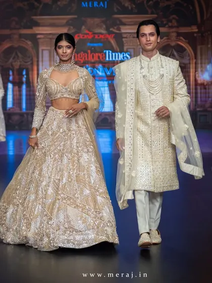 This couple walks the runway in our gold geometric-designed outfits. The groom's sherwani, with its clean lines and detailed accents, is a statement of modern luxury.