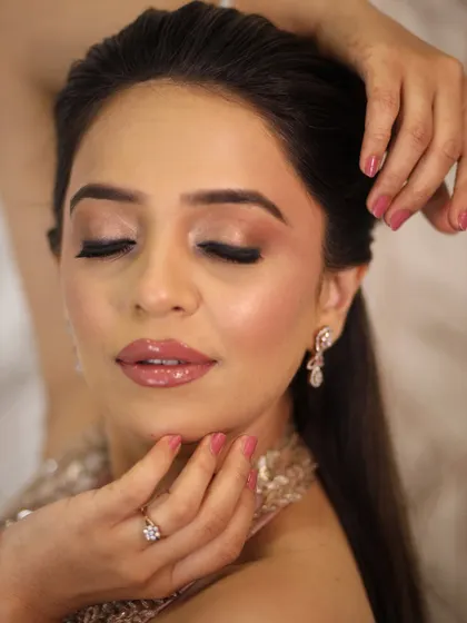 A close-up of the eye and lip details. The pink-toned shimmer and glossy nude lips are a perfect combination for a soft and romantic look.