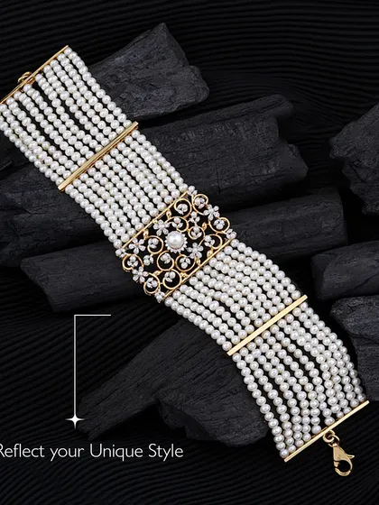 An epitome of luxury and grace. This multi-strand pearl bracelet features a magnificent diamond and pearl clasp, reflecting a timeless elegance. It is the kind of piece that feels both classic and powerful, crafted for those who cherish refined beauty.