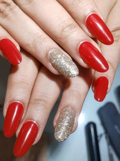 Another angle of these beautiful red and gold almond-shaped extensions. This style is perfect for brides who want their nails to be a memorable part of their wedding look.