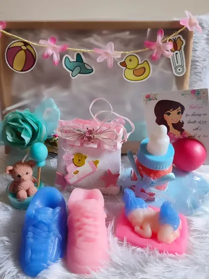 A delightful baby shower hamper with a pregnant lady lip balm card, shoe soaps, a teddy candle, and more.