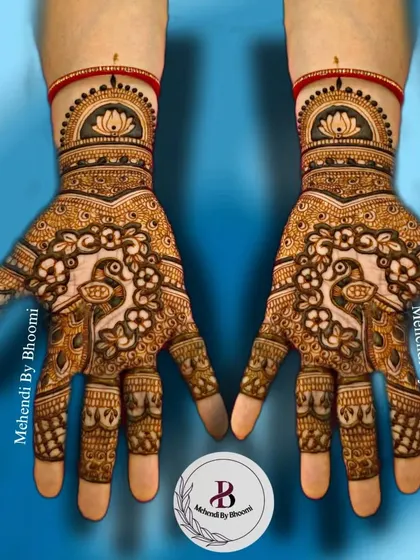 A symmetrical bridal design for the front of the hands. It features beautiful peacocks surrounded by floral patterns, with tiny elephants detailed on the fingers.