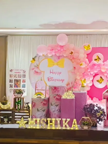 A sweet Minnie Mouse theme for Mishika's first birthday. We used shades of pink, floral-printed pedestals, and a backdrop with Minnie's iconic bow to create an adorable and girly setup.
