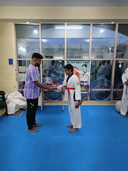 A student receives his red belt.