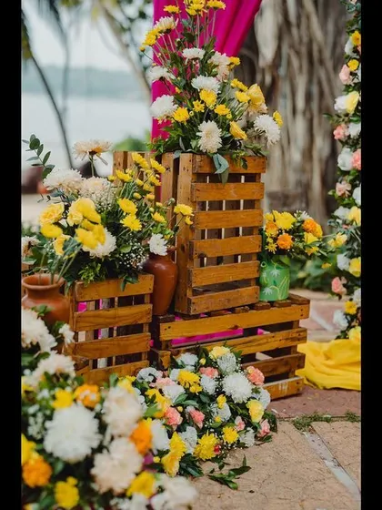 A close-up of the vibrant floral arrangements, using wooden crates to create a rustic and colorful corner at a Haldi event.