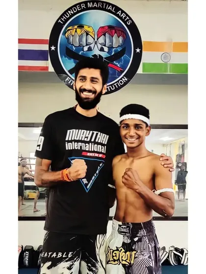 A moment of recognition during a Muay Thai grading ceremony. The Mongkhon on his head signifies respect for the art and his journey as a fighter.