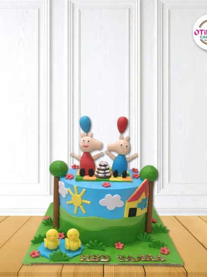 We brought Peppa Pig's world to life with this playful fondant cake. It features Peppa and George with their balloons, surrounded by a sunny landscape with trees, ducks, and their little house.