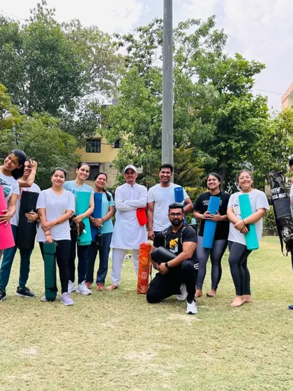 A happy group photo at the end of a session, with everyone holding their yoga mats. This captures the sense of accomplishment and community.