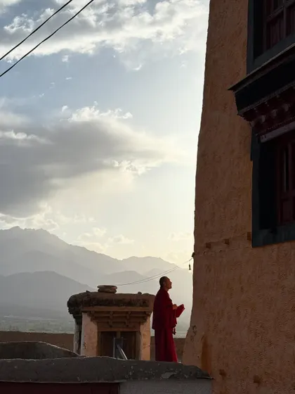 A monk stands against the backdrop of the mountains at sunset. My journey into yoga was founded on a deep faith in spirituality, and in Ladakh, this connection feels incredibly present and powerful.
