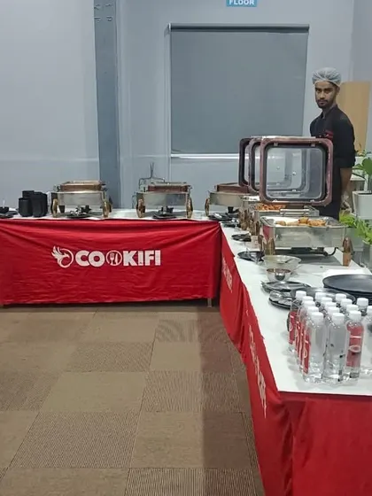 A side view of our buffet setup, showing the neat arrangement of chafing dishes, water bottles, and plates for a corporate lunch.