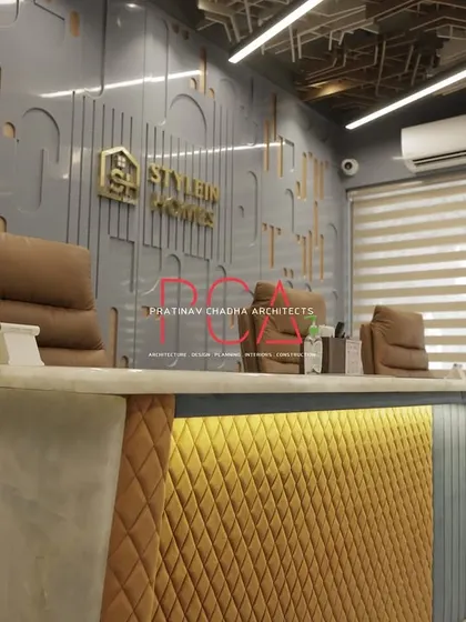 A close-up of the reception desk at StyleIn Homes, highlighting the quilted upholstery detail and under-counter lighting that adds a touch of luxury.