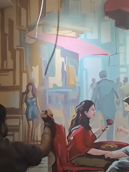 In this later stage, more characters and architectural elements are filled in, creating a bustling yet intimate city scene. The process involves carefully balancing colors and forms across the entire wall.