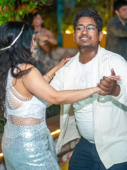 A beautiful moment of connection between two dancers, with sparkling outfits adding to the festive feel.