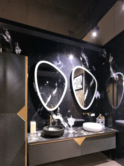 This high-drama vanity from the Fima showroom I designed features a black marble backdrop, asymmetric LED mirrors, and ribbed cabinetry.